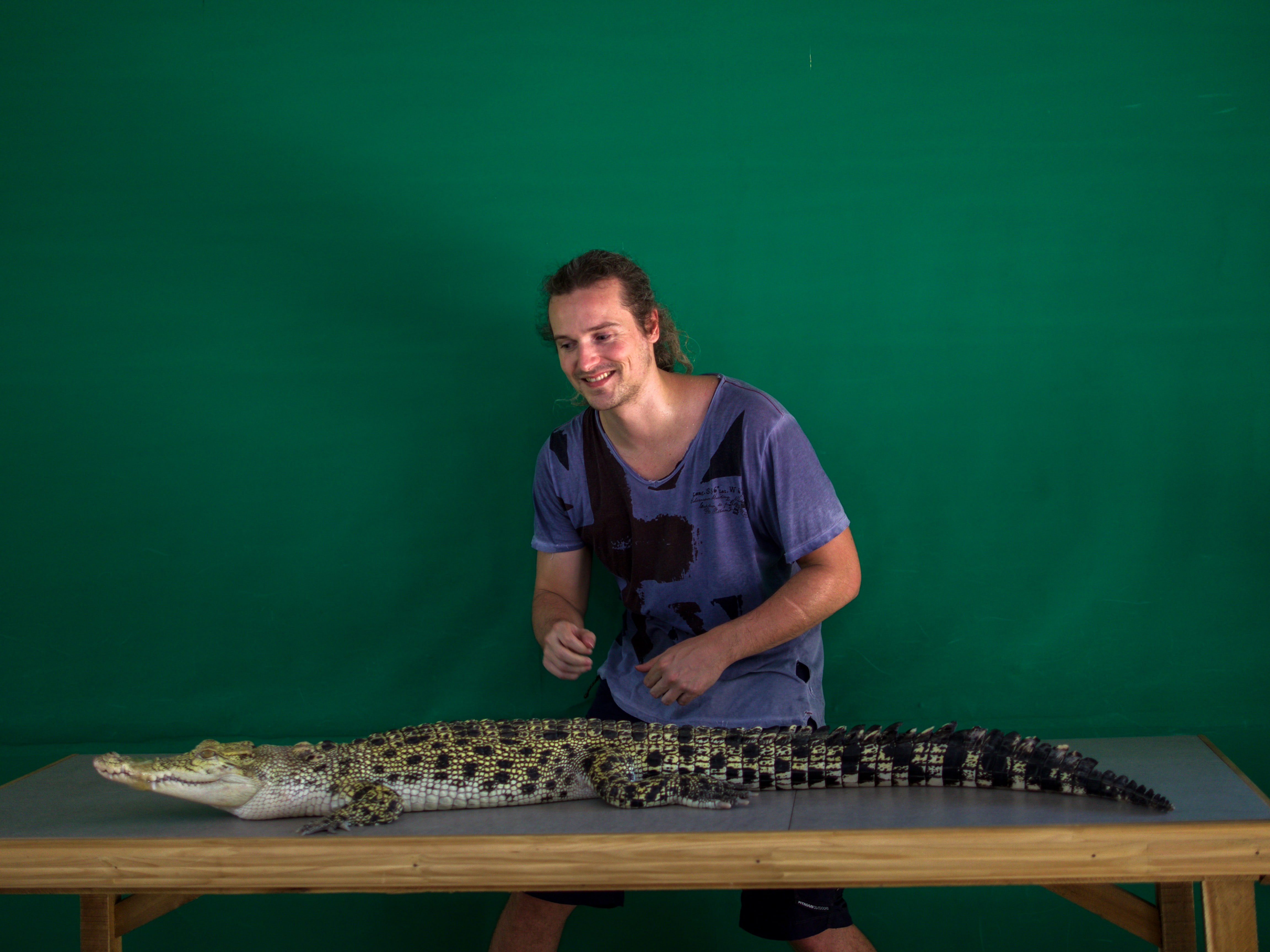 lenny through paradise grabs and poses for photo with little crocodile at Palawan Wildlife Rescue and Conservation Centre